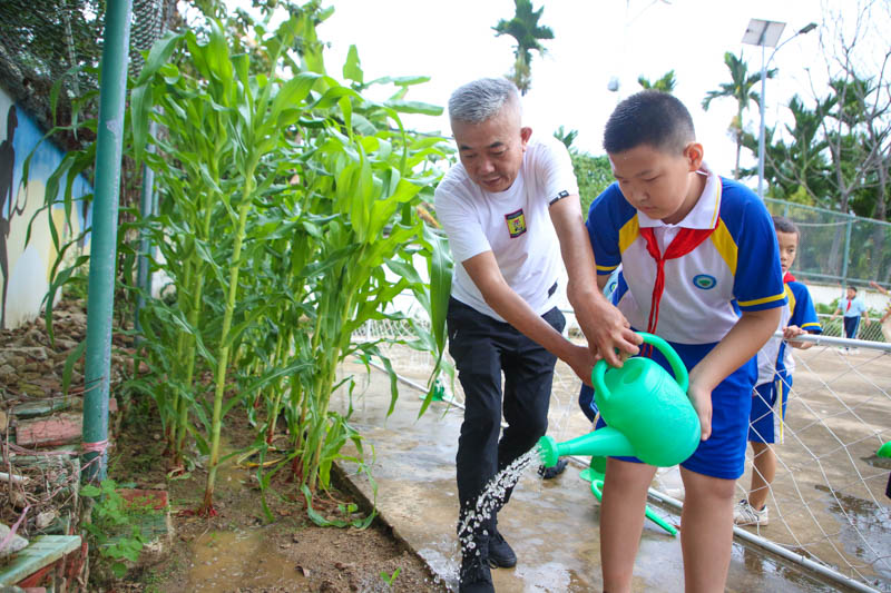 在海羅小學(xué)勞動課上，老師正手把手教學(xué)生澆水。人民網(wǎng) 牛良玉攝.jpg