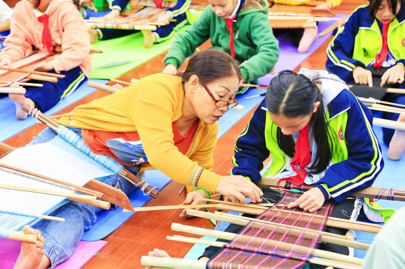 老師正在指導學生織造黎錦。紅塘小學供圖