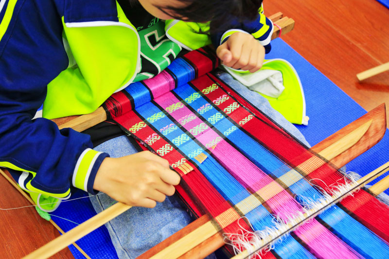學生正在認真地織造。紅塘小學供圖